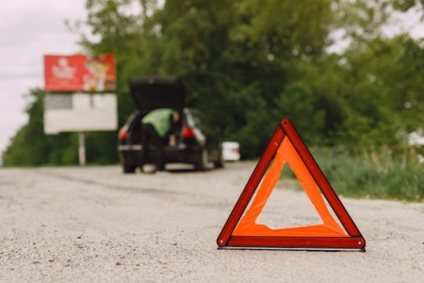 carro-com-problemas-e-um-triangulo-vermelho-para-avisar-outros-usuarios-da-estrada_1157-35969